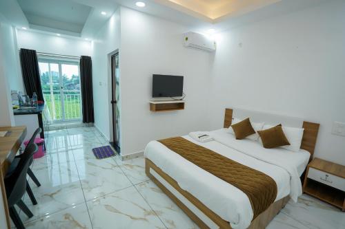 a hotel room with a bed and a television at Hotel The Mountmist in Kakkanad