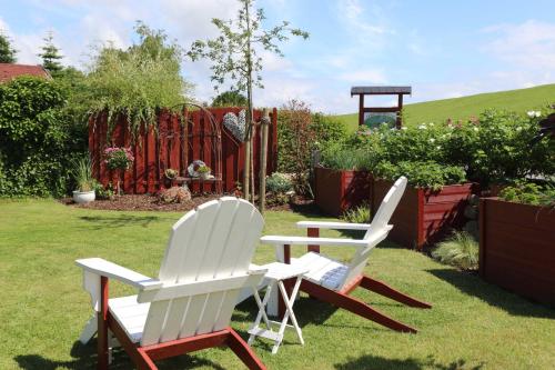 two white chairs and a table in a yard at Holthus in Kollmar
