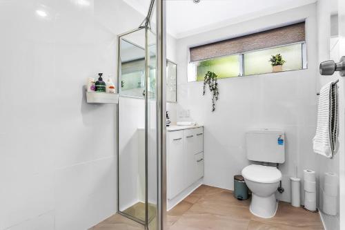a bathroom with a toilet and a glass shower at Secure Suite in Gated Complex, Courtyard, 5 Min CBD in Rose Park