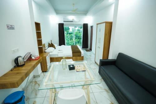 a living room with a couch and a bed at Hotel The Mountmist in Kakkanad