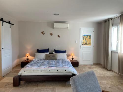 a bedroom with a large bed and two chairs at ARLES CAMPAGNE LOCATION "La Campagn'Arles" in Arles