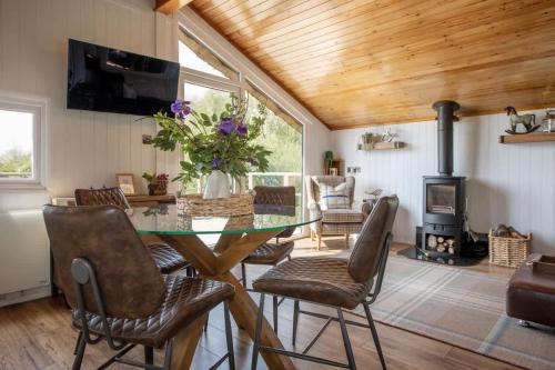 a dining room with a glass table and chairs at Tesseyman Lodge in Bubwith