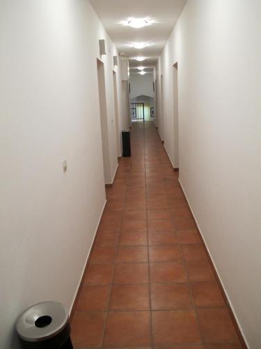 a long hallway with a tile floor and white walls at Apartments and Rooms Degenija in Starigrad-Paklenica