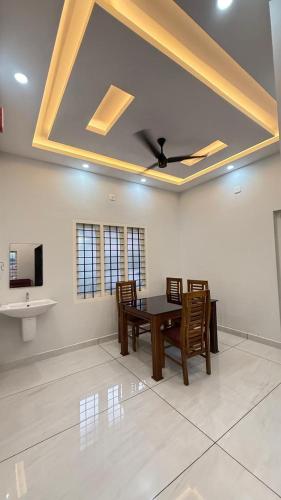 a dining room with a table and chairs and a ceiling at sahara private villa in Cochin