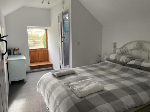 a bedroom with a bed with two towels on it at Ty Hir at Blaenbrynich Farm in Brecon