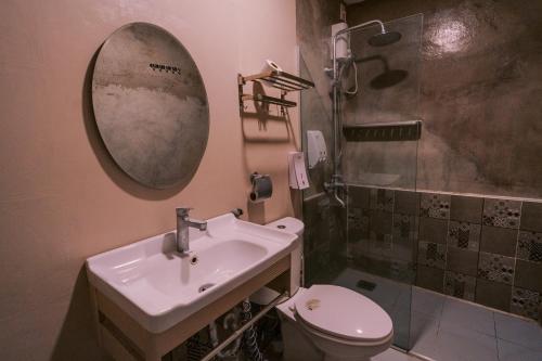 a bathroom with a sink and a toilet and a mirror at Serenity Busay Room 3 in Cebu City