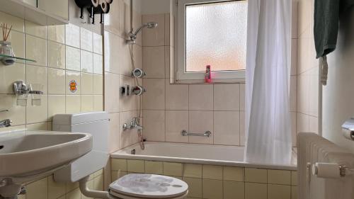 a bathroom with a sink and a toilet and a tub at Cute apartment in lovely Constance in Konstanz