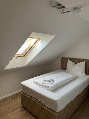 a bedroom with a bed with a window on the wall at Allgäu Residenz & Spa in Wiggensbach