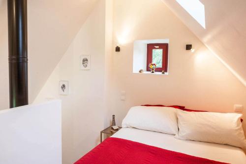 a bedroom with a red and white bed and a window at Water Mill - Private Lake - Fiber Wifi - Burgundy in Rix