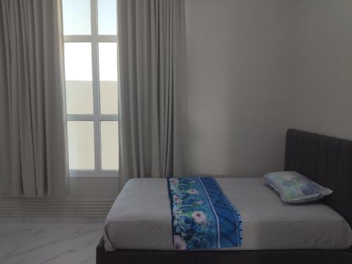a bedroom with a bed and a window with curtains at منزل للإيجار اليومي in Ḩilf