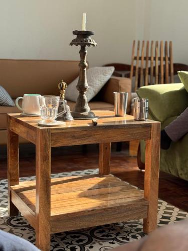 a wooden coffee table with a candle on top at Calmsutra retreat in Sānkhu