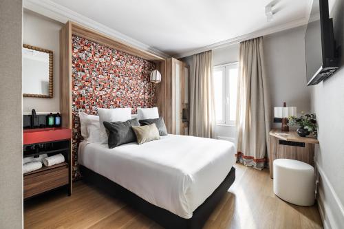 a bedroom with a large white bed with a red wall at One Shot La Latina in Madrid