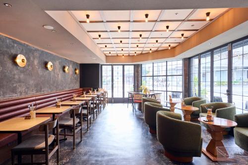 a restaurant with tables and chairs and windows at Hotel Vintage Tokyo Meguro Fudomae in Tokyo