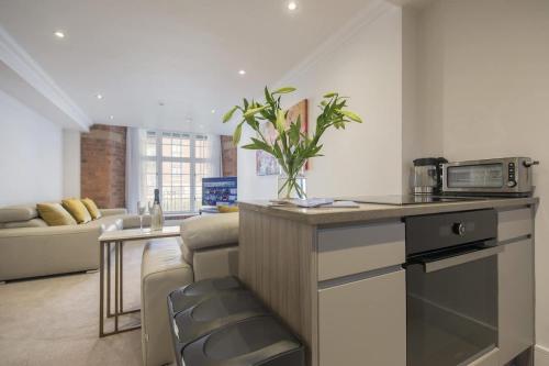 a kitchen and living room with a couch and a microwave at ChocoLets - The Lion Suite in York
