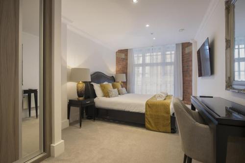 a bedroom with a bed and a desk and a mirror at ChocoLets - The Lion Suite in York