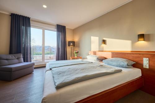 a bedroom with a large bed and a window at Hotel Viva Bröckel in Bröckel