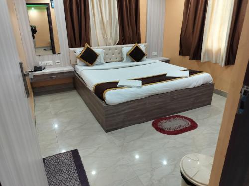 a bedroom with a large bed with a mirror at Hotel Tara Darshan in Tarapith