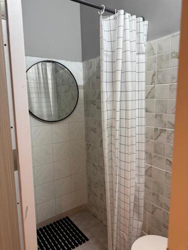 a bathroom with a shower with a mirror at Hostel Samui in Nathon Bay
