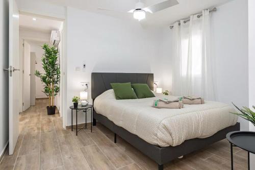 a bedroom with a large bed with green pillows at Monte Tulum in Torrent
