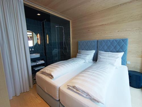 a bed with a blue headboard in a bedroom at Jules - Come Together in Stuben am Arlberg