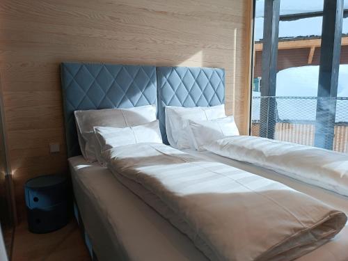 a large bed with white pillows in a room at Jules - Come Together in Stuben am Arlberg
