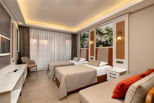 a hotel room with two beds and a couch at Club Hotel Phaselis Rose in Tekirova