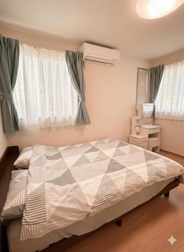 a bedroom with a bed and a window at 熊本Station one in Kumamoto