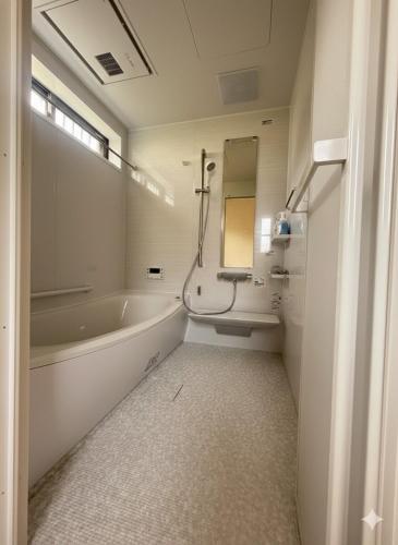 a bathroom with a bath tub and a sink at 熊本Station one in Kumamoto
