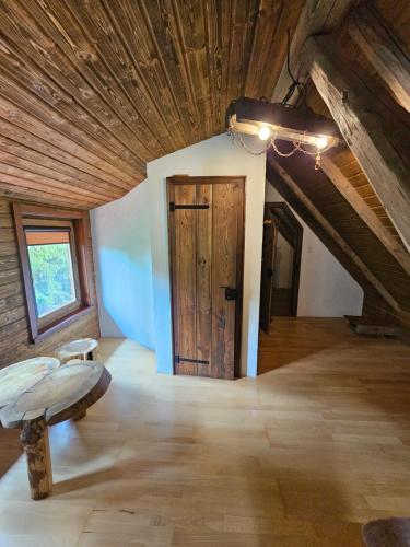 a room with a wooden ceiling and a door at Chata Horáreň in Smižany