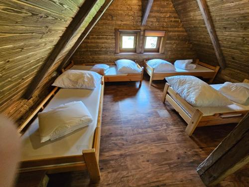 a room with four bunk beds in a log cabin at Chata Horáreň in Smižany