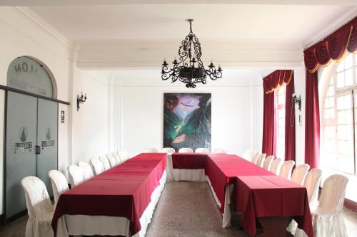 a dining room with a red table and white chairs at Hotel de Turistas Abancay in Abancay