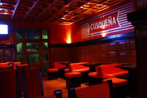 a restaurant with red chairs and a sign on the wall at Hotel de Turistas Abancay in Abancay