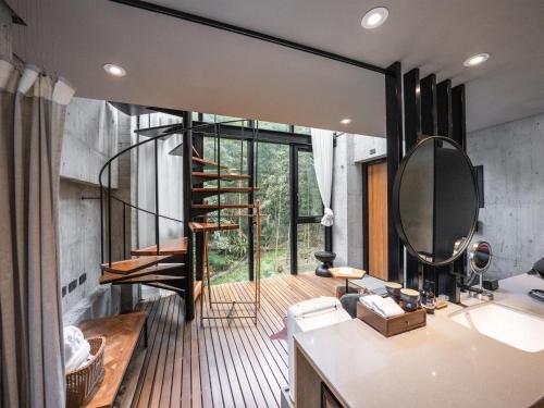 a bathroom with a staircase and a mirror at Deer Chaser Xitou in Lugu Lake