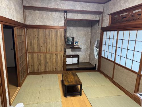 a room with a wooden door and a table at ぺろんち in Shinkamigoto