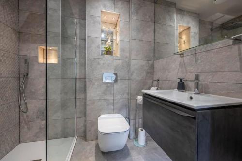 a bathroom with a toilet and a sink and a shower at The Quadrant - The Ruskin Suite in York