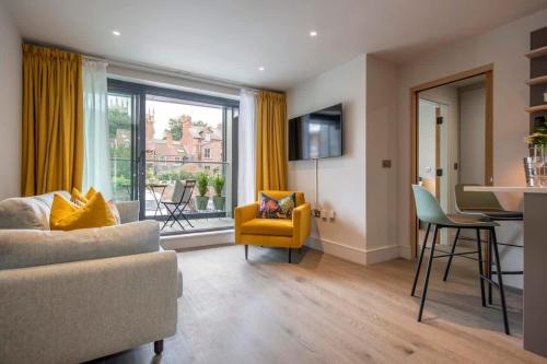 a living room with a couch and a table and chairs at The Quadrant - The Ruskin Suite in York