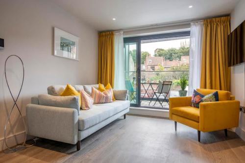 a living room with a couch and a chair and a window at The Quadrant - The Ruskin Suite in York