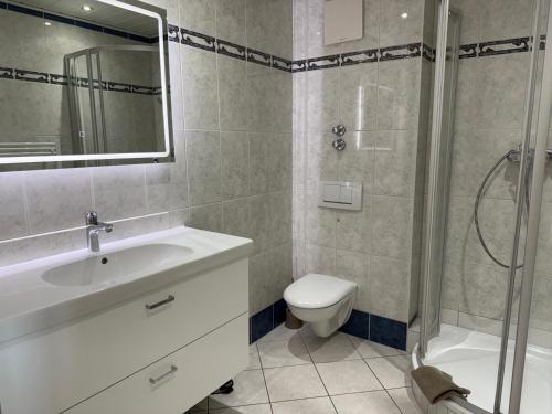 a bathroom with a sink and a toilet and a shower at Appartementhaus Hoppe in Sylt