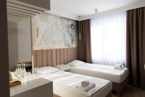a hotel room with two beds and a window at Hotel Przystań Przy Lesie in Lewiczyn