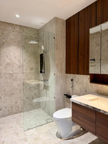 a bathroom with a shower and a toilet and a sink at AMA Residences in Buon Ma Thuot