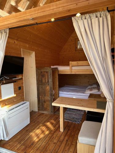a room with a bunk bed and a desk in a cabin at Ribno Alpine Glamping in Bled