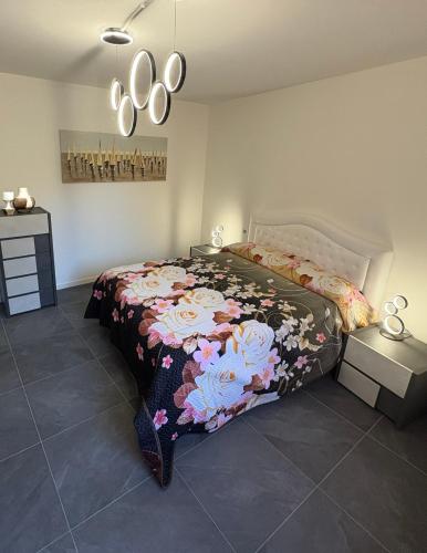a bedroom with a bed with a floral bedspread at Ami Affittacamere 4 in Castel San Giovanni