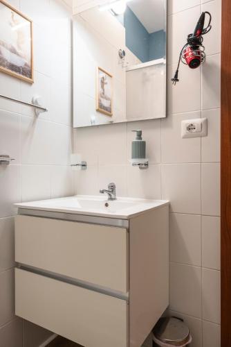 a white bathroom with a sink and a mirror at Maison all'Arco in Corridonia