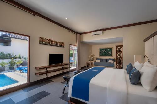 a bedroom with a large bed and a swimming pool at Rama Residence Seminyak in Seminyak