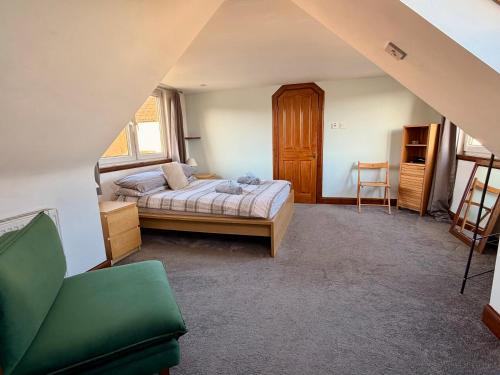 a bedroom with a bed and a chair in it at Cosy 2 bedroom home with free parking near city in Edinburgh