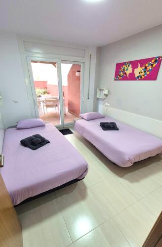 two beds in a room with pink sheets at Citadel Oliva 4p Roses, Beach & Centre, Private Parking, Terrace in Roses