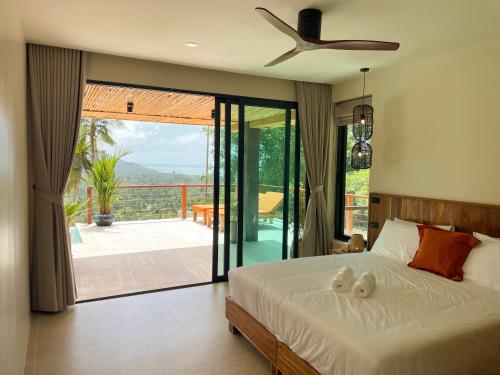 a bedroom with a bed and a view of a patio at Altura Villa Pool & Panoramic View in Ban Nong Chaeng