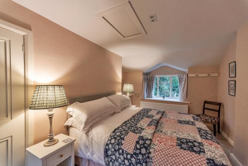 a bedroom with a bed and a lamp and a window at Finest Retreats - Dolhyfryd Lodge in Denbigh
