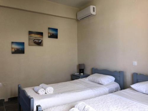 a room with two beds with towels on them at Sidari High Street Apartment in Sidari