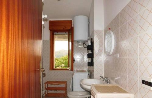 a bathroom with a sink and a toilet and a window at Casa COMER GRISOLIA in Cirella